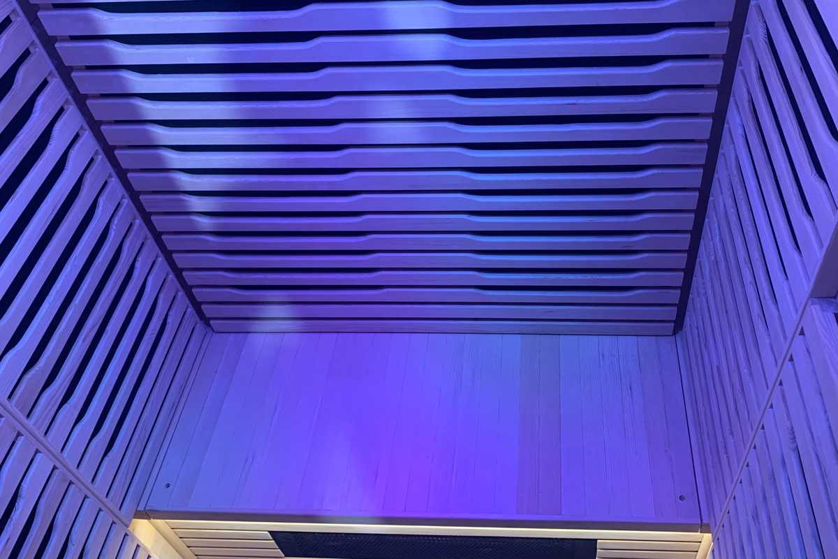 Interior view of Blisspod Helsinki Deluxe infrared sauna showing bench area and blue ambient lighting