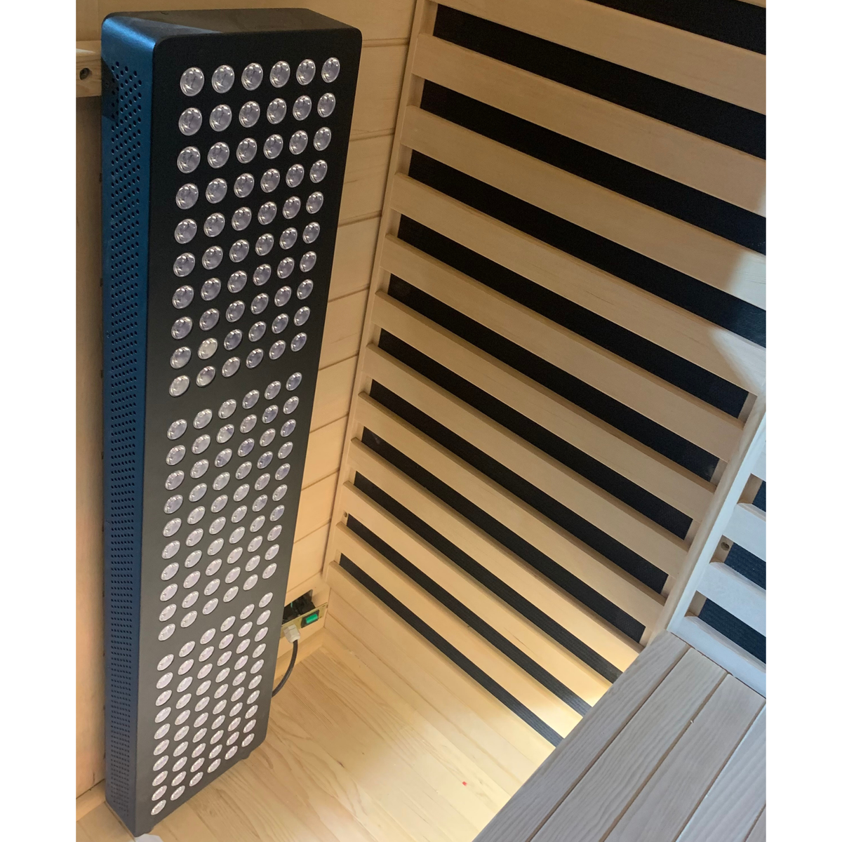 Infrared heating panel and wooden heater guards inside the Blisspod Bergen Deluxe sauna
