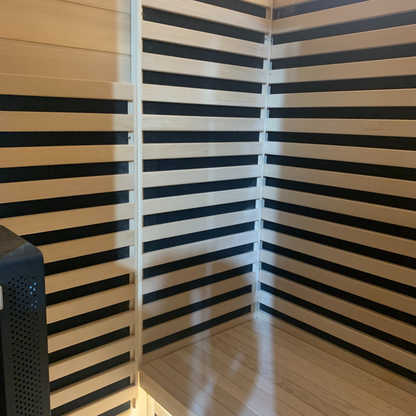 Interior seating area with wooden bench and heater guards inside the Blisspod Bergen Deluxe sauna
