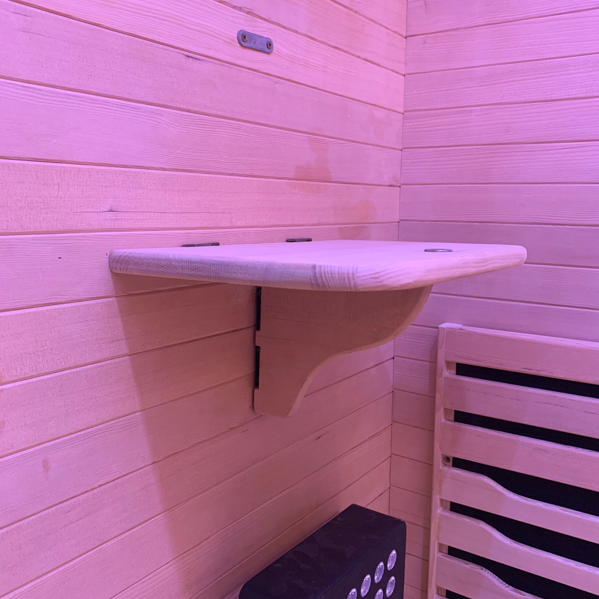 Foldable interior shelf inside Blisspod Helsinki Deluxe infrared sauna with pink ambient lighting