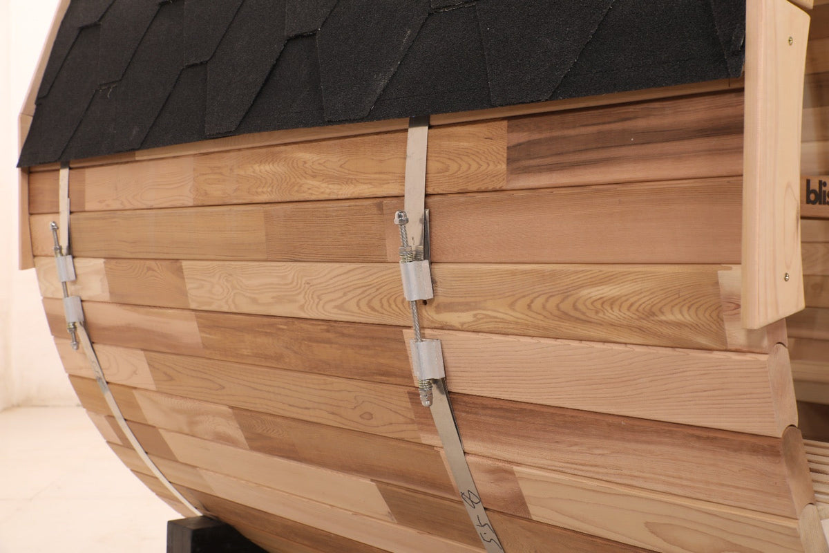 Side detail of the Blisspod Prague barrel sauna showing cedar boards and metal bands