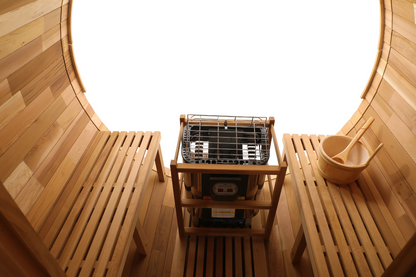 Electric heater between two cedar benches beneath the glass back of the Blisspod Prague barrel sauna