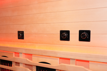 Interior wood wall of the Blisspod Venetian RED sauna with black control panels above the bench