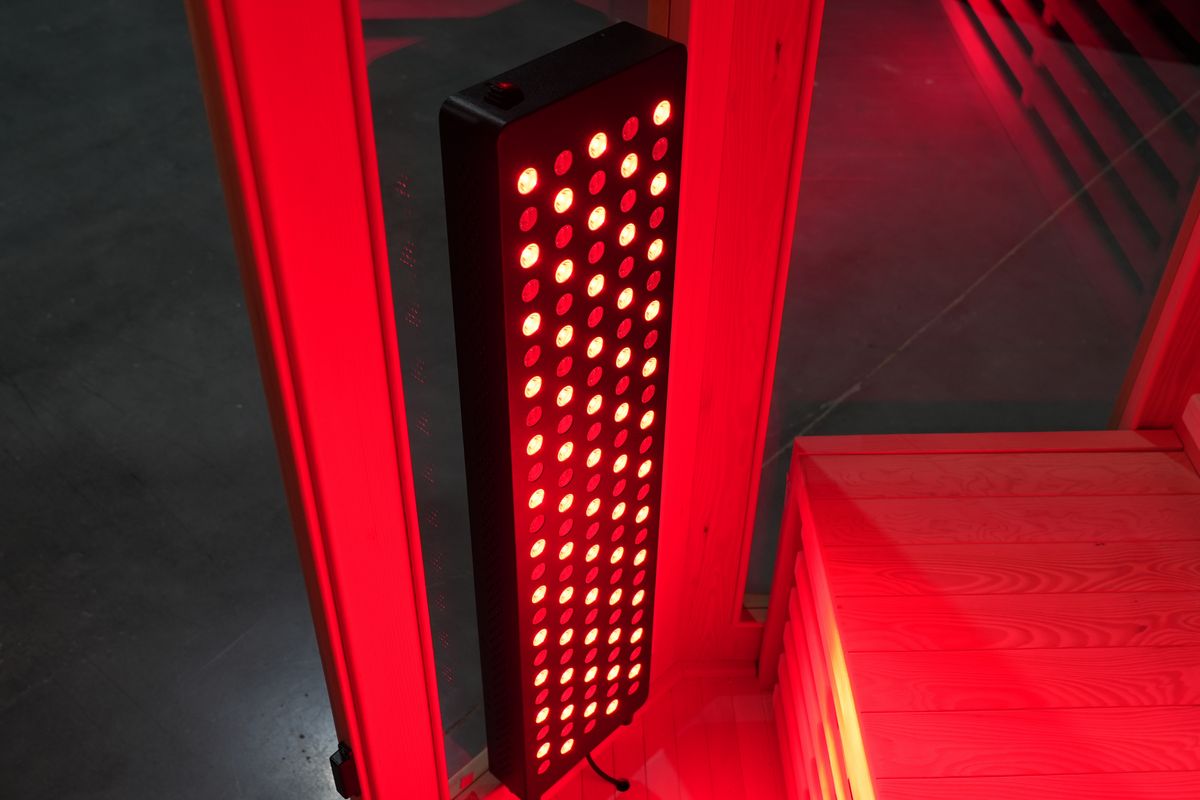 Illuminated red light therapy panel inside the Blisspod Vienna RED infrared sauna
