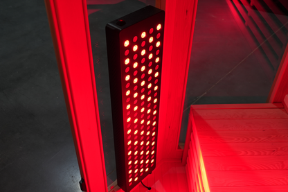Illuminated red light therapy panel inside the Blisspod Vienna RED infrared sauna
