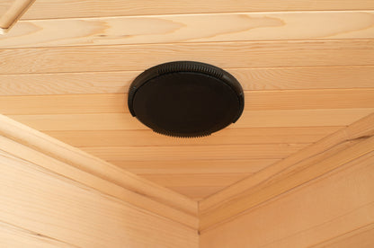 Built-in circular speaker set into the wood ceiling of the Blisspod Vienna sauna