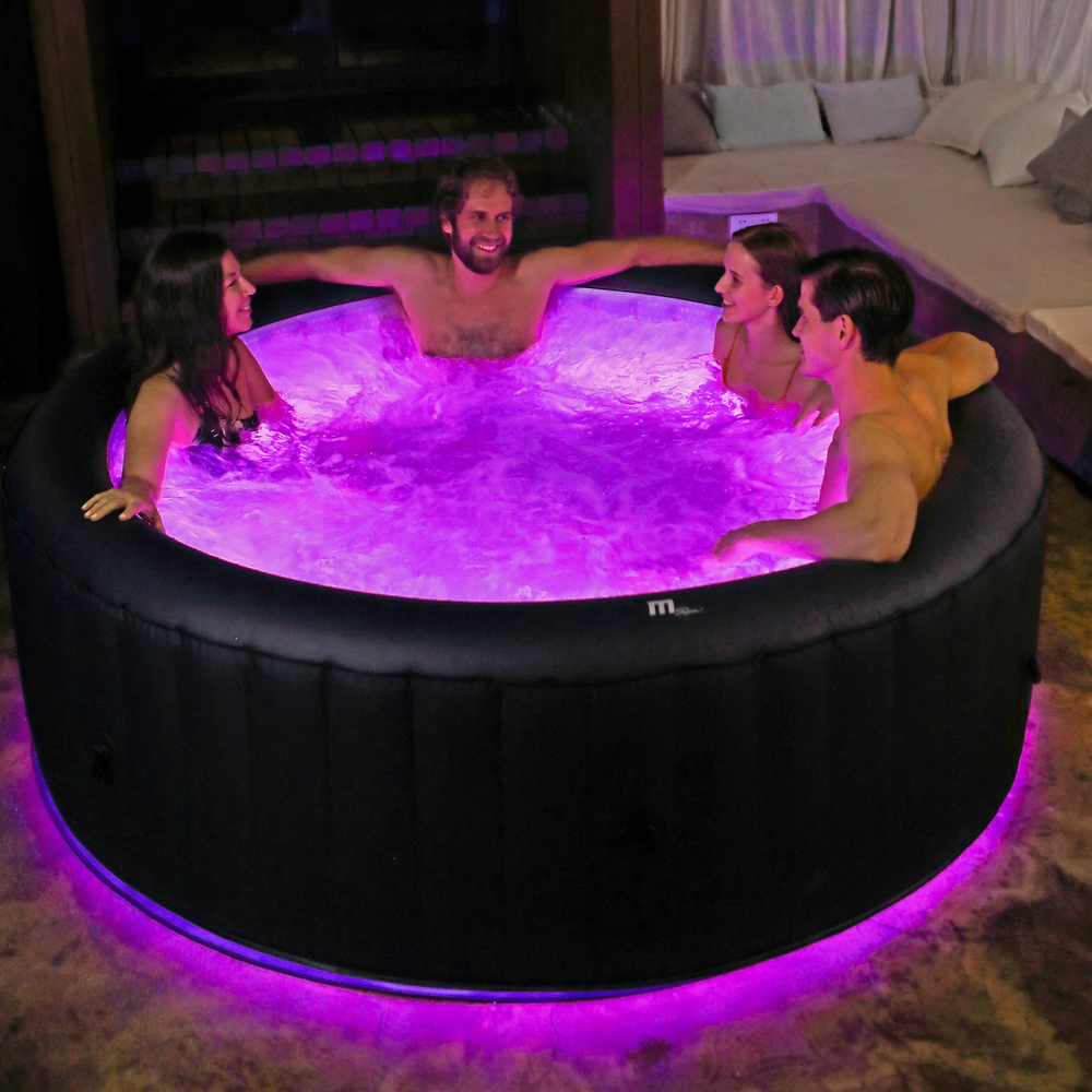 People enjoying the MSpa AURORA hot tub illuminated with purple LED lighting
