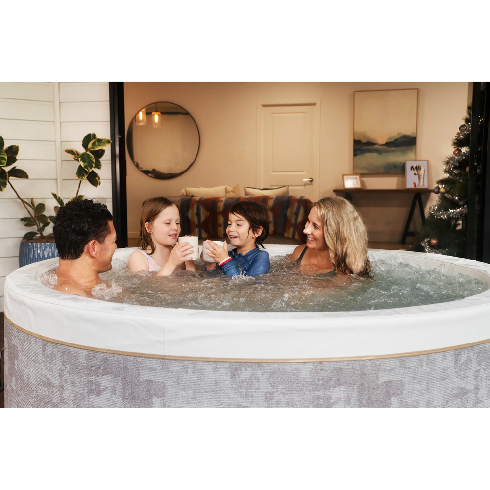 Family of four, two parents and two children, enjoying the MSpa COCOON 6-person rigid foam hot tub together