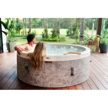 MSpa COCOON rigid foam hot tub on an outdoor patio with a person standing beside it
