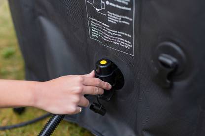 Close-up of a hand adjusting an exterior connection on the MSpa Tekapo inflatable hot tub